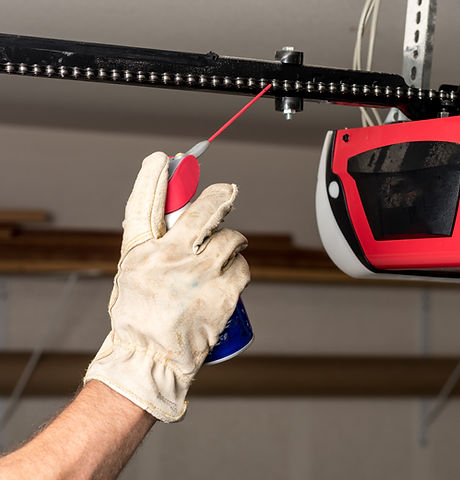 garage door tune up - Applying Oil to Chain of Garage Door